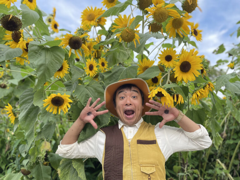 ひまわりに囲まれてポーズをとる平野らすかる