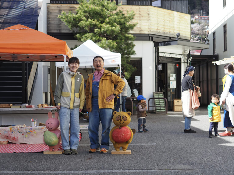 屋外の出展ブースで作品と並ぶ、うさぎとたぬきの二人